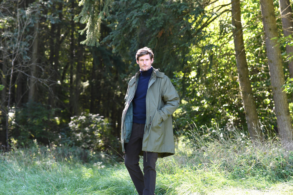 Outdoorjacken — olivgrüne Parka-Jacke im Nadelwald